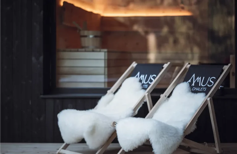 Bedruckte Liegestühle mit Fellen vor einem Chalet